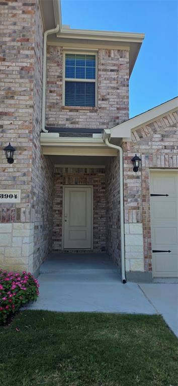 3904 Malachite Drive, Celina, TX 75009 Brick and stone exterior with a recessed entry, covered porch, and integrated garage