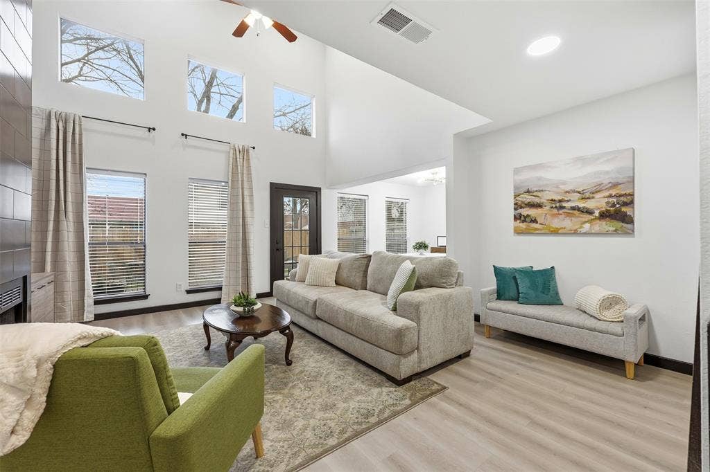 Vaulted ceiling with a ceiling fan, light wood-finish flooring, recessed lighting, and multiple windows
