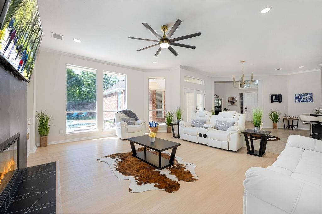 2007 Hill Haven Circle, Richardson, TX 75081 Recessed lighting, wood-finish flooring, a modern ceiling fan, a built-in fireplace with a black stone surround, and large windows