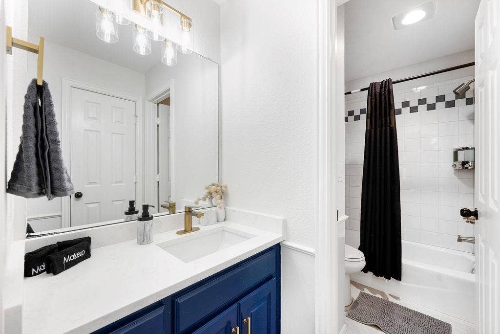 2007 Hill Haven Circle, Richardson, TX 75081 Bathroom featuring a white vanity with a blue cabinet, a single-basin sink, and a gold-finish faucet