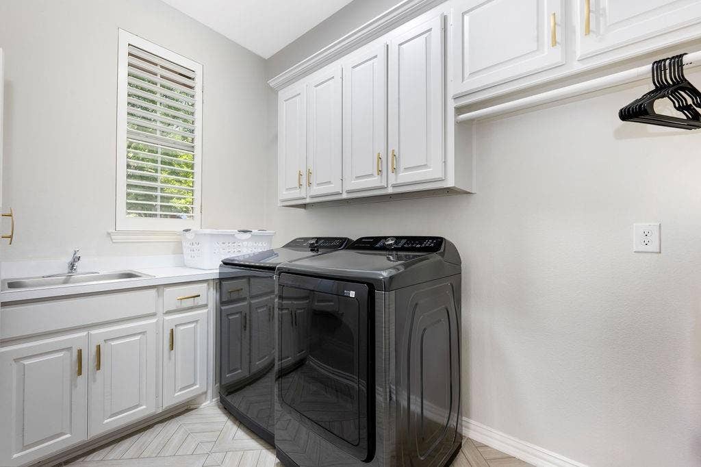2007 Hill Haven Circle, Richardson, TX 75081 White cabinetry with gold-tone hardware, stainless steel sink, light-toned countertop, and herringbone-patterned flooring