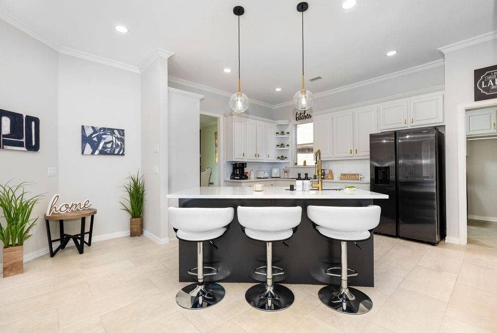 2007 Hill Haven Circle, Richardson, TX 75081 Kitchen featuring a central island with white countertop, white upper and lower cabinetry, black stainless steel refrigerator, and recessed lighting