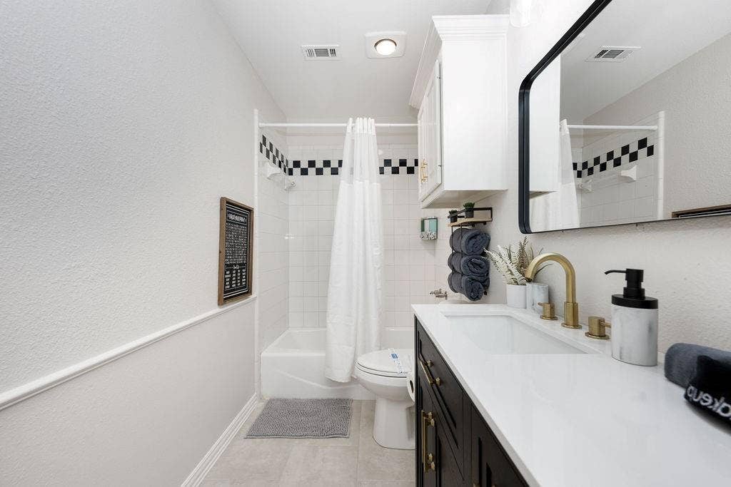 2007 Hill Haven Circle, Richardson, TX 75081 White tile shower with checkerboard accent, single vanity with white countertop, brass finish faucet, and recessed lighting