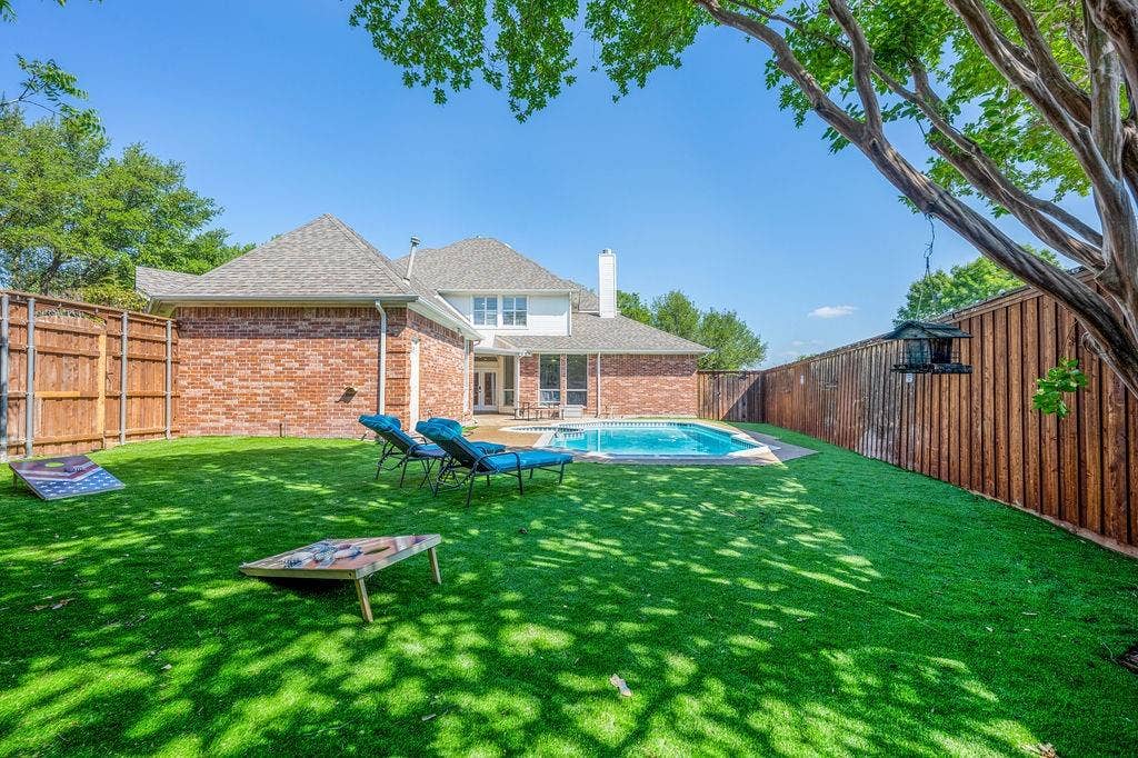 2007 Hill Haven Circle, Richardson, TX 75081 Spacious backyard featuring artificial turf, a rectangular swimming pool, and wood privacy fencing