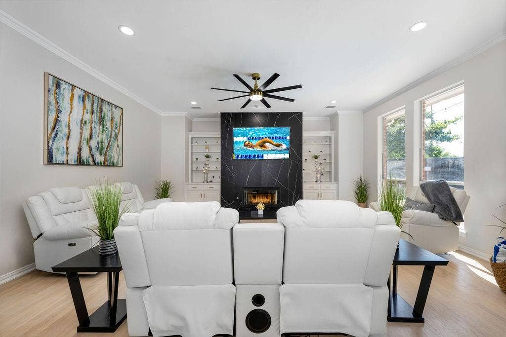 2007 Hill Haven Circle, Richardson, TX 75081 Recessed lighting, wood-finish flooring, crown molding, and a modern ceiling fan complement the black stone-clad fireplace with built-in shelving