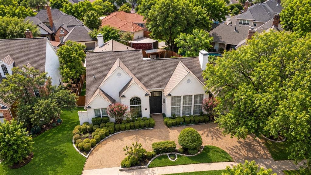 4612 Saxon Drive, Plano, TX 75093 White exterior residence featuring a gabled roof, arched entry, and well-maintained landscaping