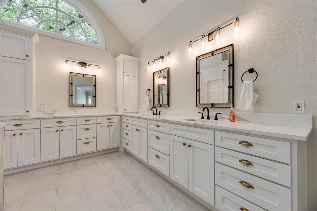 4612 Saxon Drive, Plano, TX 75093 Dual vanity with white cabinetry and gold-tone hardware