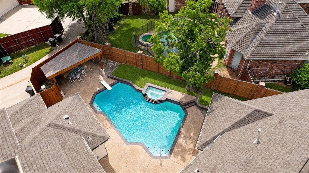 4612 Saxon Drive, Plano, TX 75093 Geometric swimming pool with integrated spa, diving board, and surrounding concrete patio