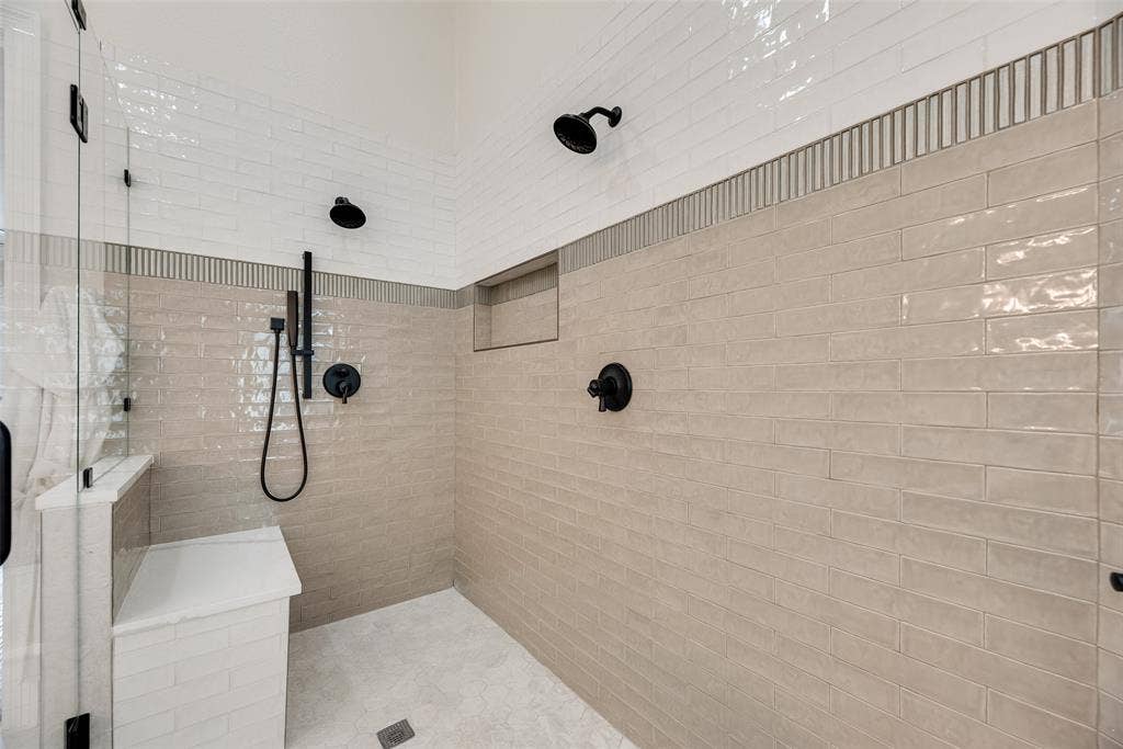 4612 Saxon Drive, Plano, TX 75093 Walk-in shower with dual showerheads, matte black fixtures, built-in bench, and recessed shelf