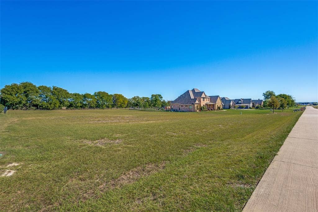 C-14 Waterstone Estates, McKinney, TX 75071 Expansive grass area with a concrete pathway and a backdrop of mature trees