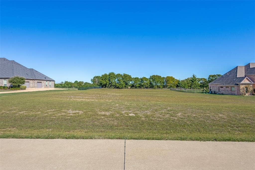 C-14 Waterstone Estates, McKinney, TX 75071 Expansive grassy lot with surrounding mature trees and a clear sky