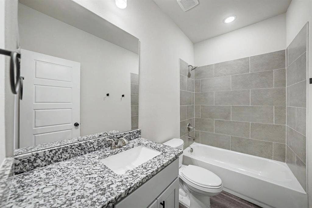 Vanity with granite countertop, integrated sink, and brushed nickel faucet