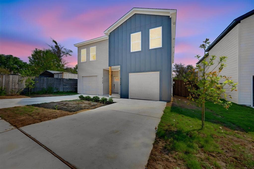 Modern exterior featuring vertical siding, a two-car garage, and concrete driveway