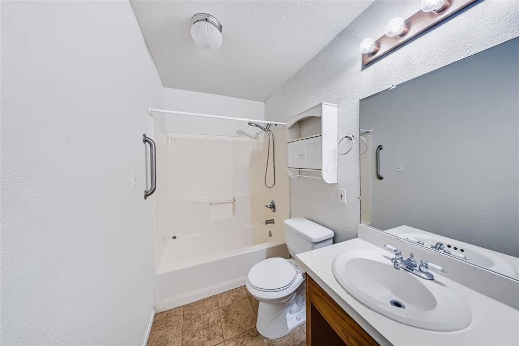 560 Green Acres Road, Weatherford, TX 76088 Bathroom with a single vanity, large mirror, and full bathtub with shower