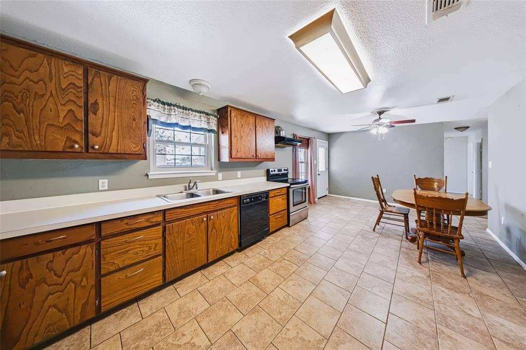 560 Green Acres Road, Weatherford, TX 76088 Kitchen with wood cabinetry, light-toned countertops, and a double-basin sink