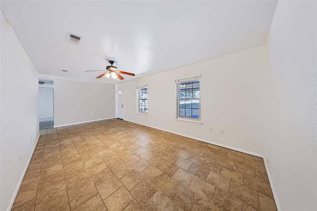 560 Green Acres Road, Weatherford, TX 76088 Tile flooring, ceiling fan, multiple windows with blinds, and a white entry door