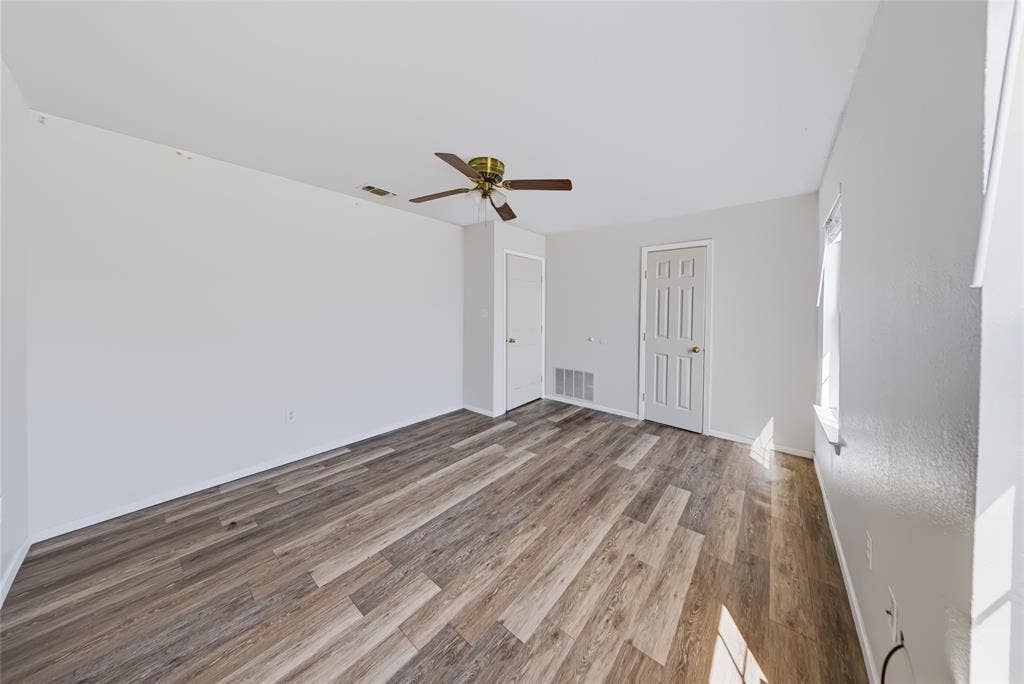 560 Green Acres Road, Weatherford, TX 76088 Main Home – Spacious interior with wood-finish flooring, ceiling fan, and crisp white walls