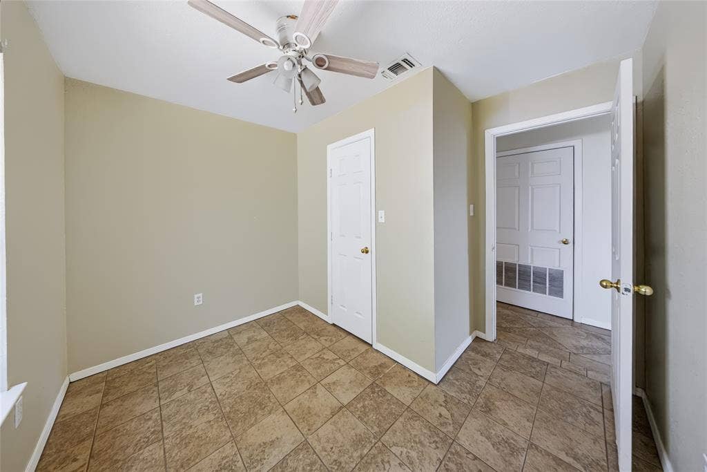 560 Green Acres Road, Weatherford, TX 76088 Main Home – Tile flooring, white paneled doors, ceiling fan with light fixture, and neutral wall paint