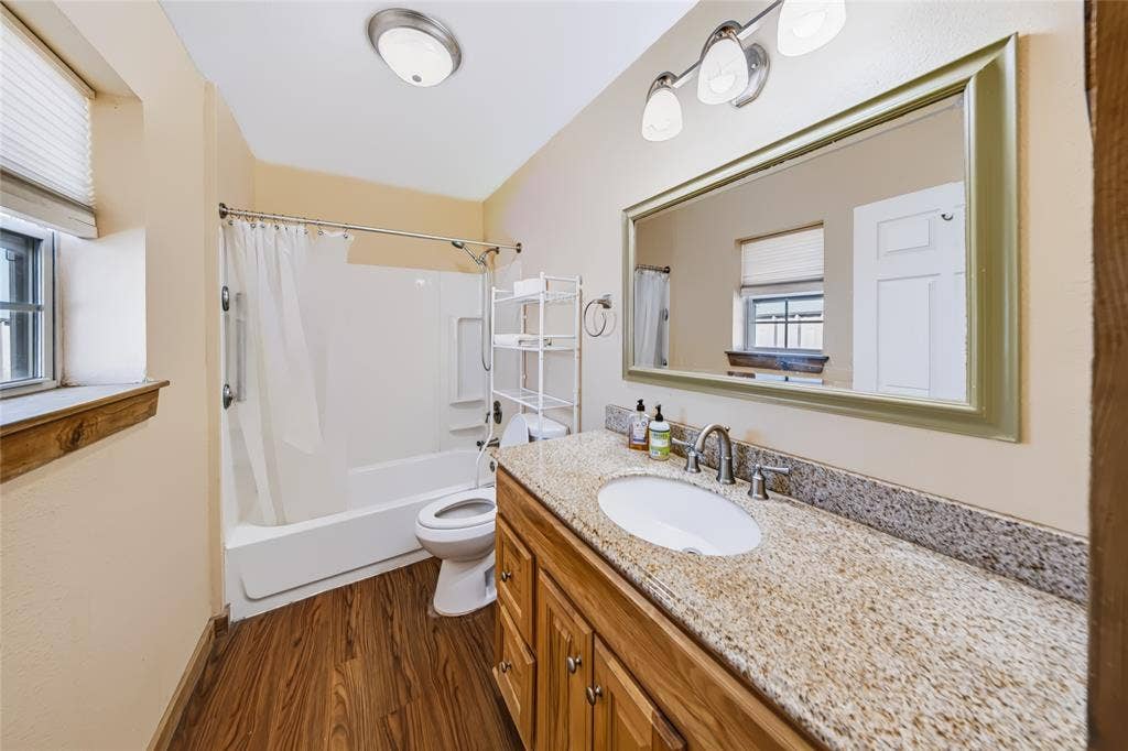 560 Green Acres Road, Weatherford, TX 76088 Wood-finish flooring, single vanity with light-toned countertop, integrated sink, and brushed nickel faucet