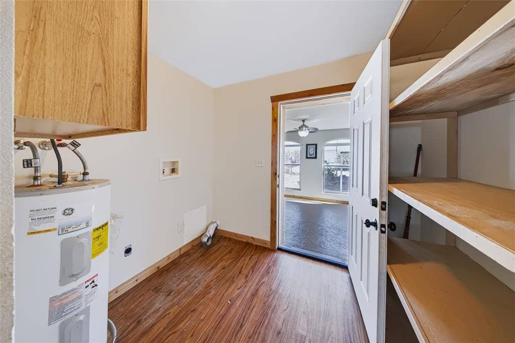 560 Green Acres Road, Weatherford, TX 76088 Utility space with wood-finish flooring, built-in shelving, and a wood-paneled door frame