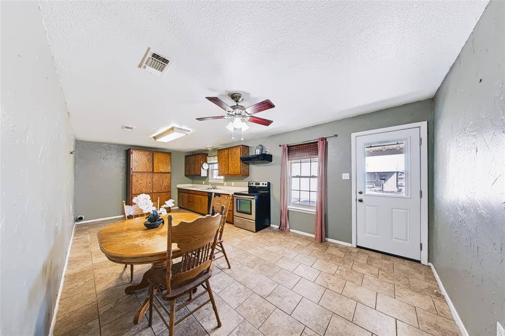 560 Green Acres Road, Weatherford, TX 76088 Main Home – Kitchen and dining area featuring tile flooring, wooden cabinetry, stainless steel appliances, and a ceiling fan