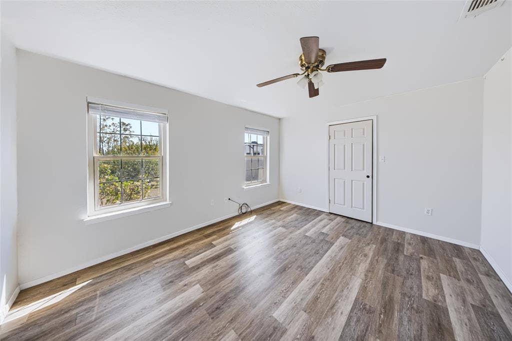 560 Green Acres Road, Weatherford, TX 76088 Main Home – Spacious room with wood-finish flooring, white walls, and two windows