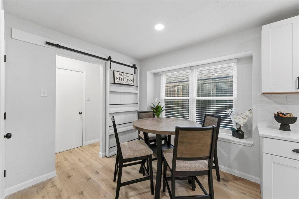 Wood-finish flooring, recessed lighting, and a barn door entry