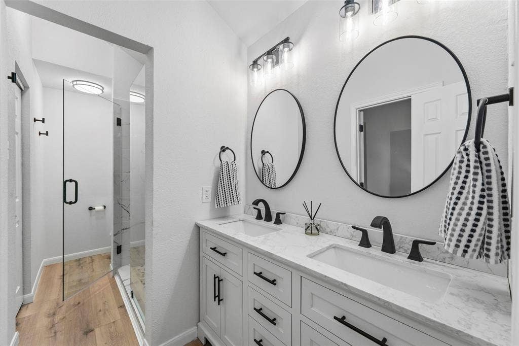 Dual vanity with undermount sinks, stone-look countertop, and matte black hardware