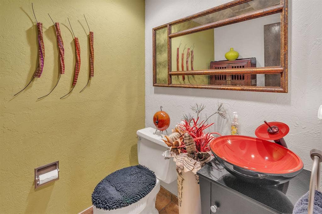Glamorous half bath in hallway with artistic sink and faucet