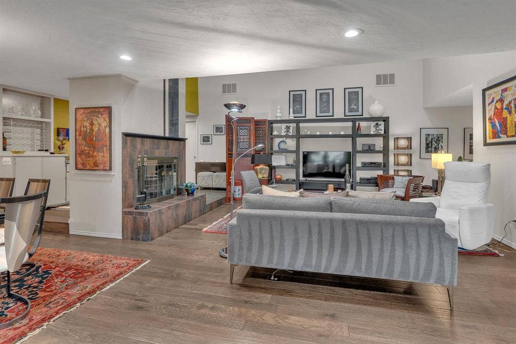 Living area with recessed lighting, wood burning fireplace, and wet bar