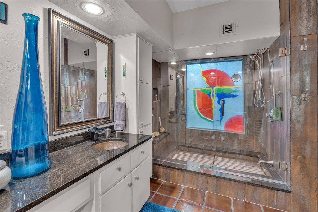 Primary bath with opulent stained glass in the shower tub area. Teak floor can be removed for tub use.