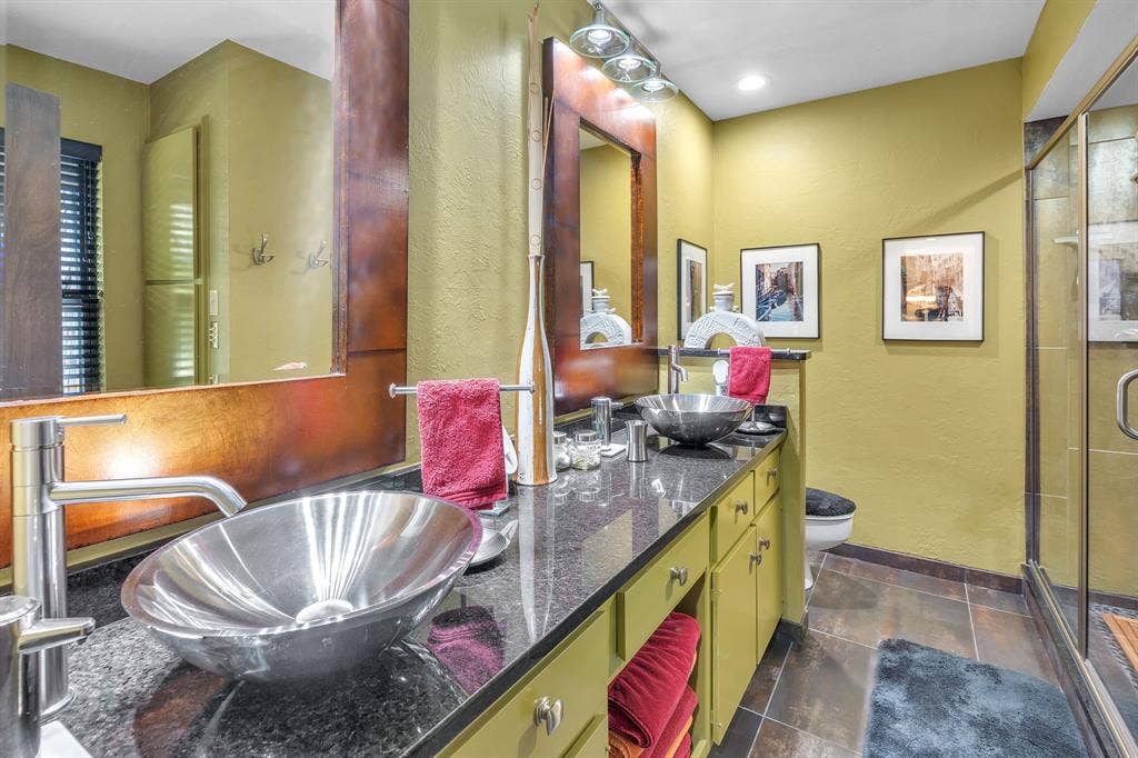 Upstairs bathroom with double stainless steel sinks and clear glass walk in shower