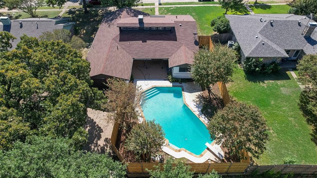 1903 Clemson Drive, Richardson, TX 75081 Expansive backyard featuring a kidney-shaped swimming pool, surrounding patio, and wood privacy fencing
