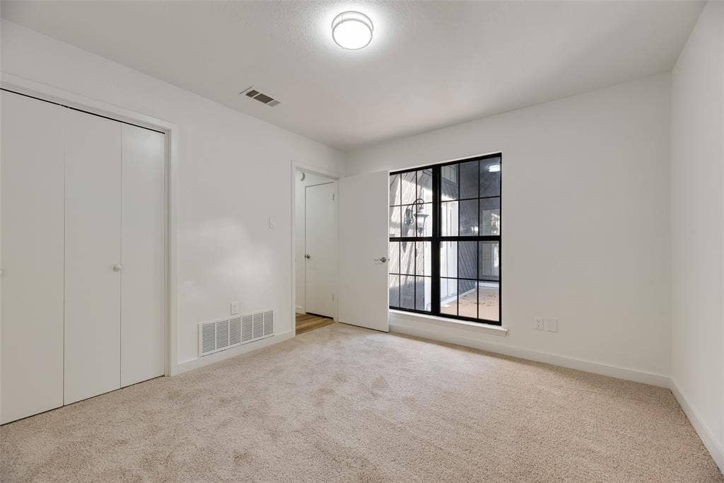 1903 Clemson Drive, Richardson, TX 75081 Carpet flooring, white walls, bi-fold closet doors, ceiling-mounted light fixture, and a window with black grid panes