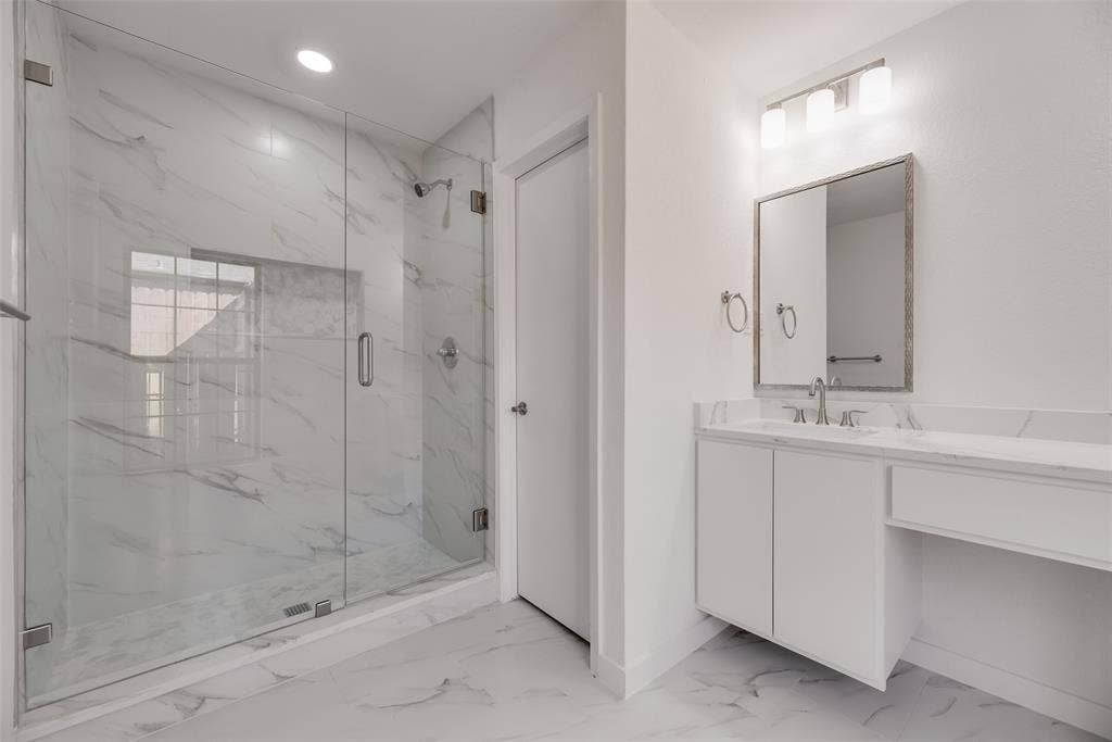 1903 Clemson Drive, Richardson, TX 75081 Walk-in shower with clear glass enclosure and marble-look tile