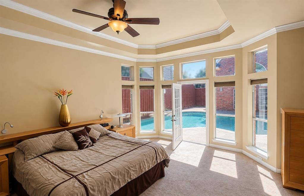 4505 Southgate Drive, Plano, TX 75024 Tray ceiling with a ceiling fan, bay window with multiple panes, double French doors, and direct access to a swimming pool