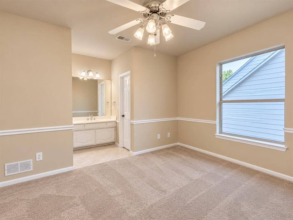 4505 Southgate Drive, Plano, TX 75024 Carpeted room with a ceiling fan light fixture, a large window, and decorative wall molding