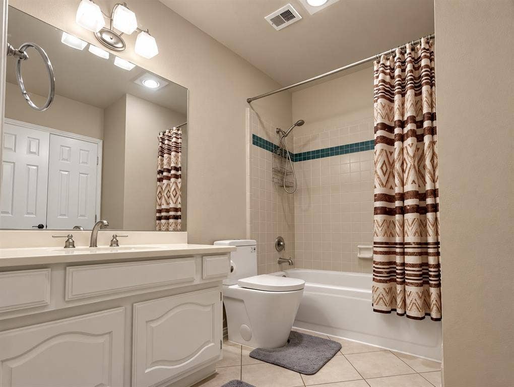 4505 Southgate Drive, Plano, TX 75024 White vanity with integrated countertop, chrome faucet, and rectangular mirror