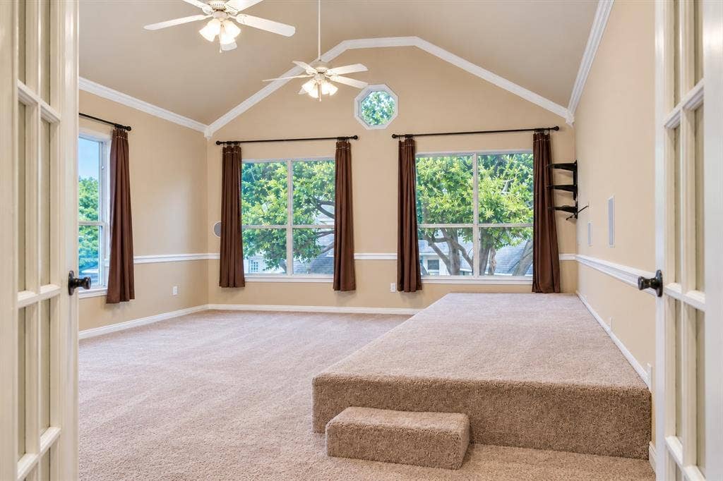 4505 Southgate Drive, Plano, TX 75024 Vaulted ceiling with crown molding, two ceiling fans, and an octagonal window