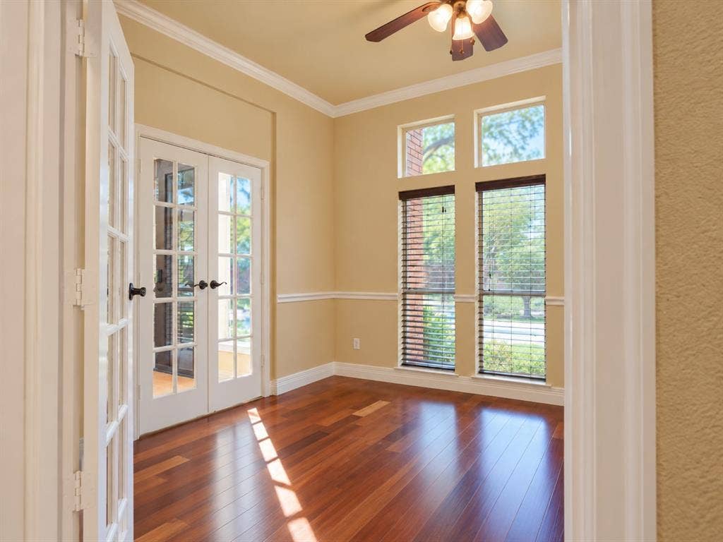 4505 Southgate Drive, Plano, TX 75024 Double French doors, wood-finish flooring, crown molding, double windows with blinds, and a ceiling fan with light fixture