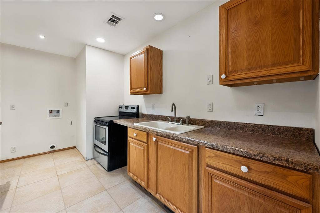 6472 Mark Drive, Burleson, TX 76028 Tile flooring with integrated lighting, wood cabinetry, built-in sink, and a standalone range