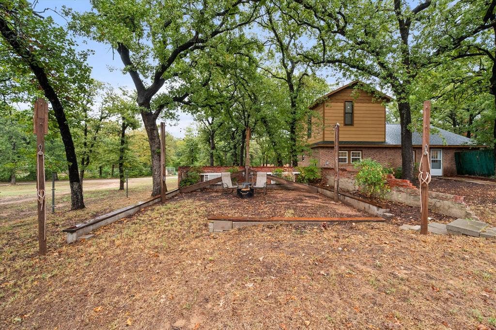 6472 Mark Drive, Burleson, TX 76028 Brick and siding exterior with a multi-level design, surrounded by mature trees