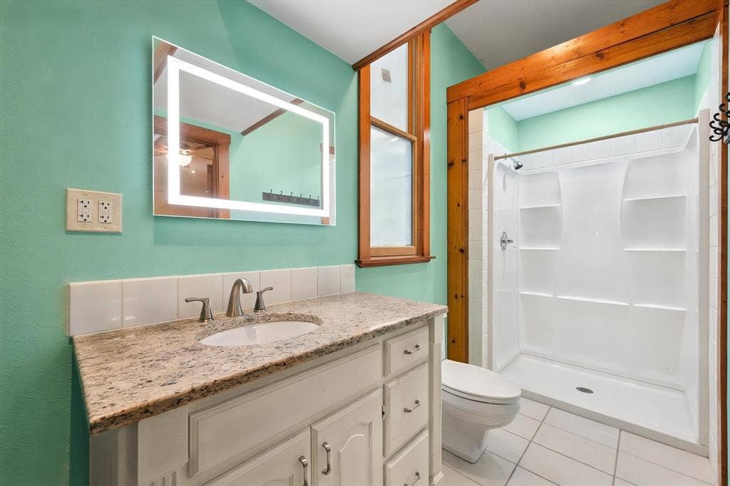 6472 Mark Drive, Burleson, TX 76028 Vanity with stone-finish countertop, undermount sink, and brushed nickel faucet