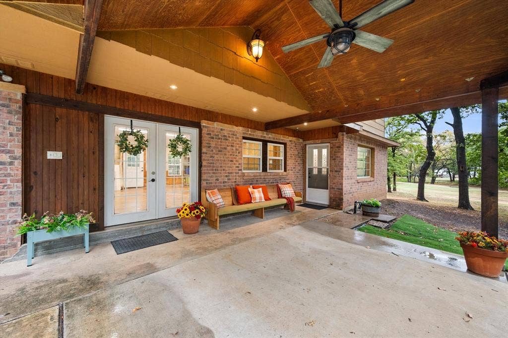 6472 Mark Drive, Burleson, TX 76028 Expansive covered patio with a wood-plank ceiling, exposed beams, and a ceiling fan