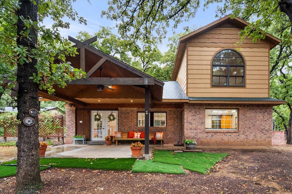6472 Mark Drive, Burleson, TX 76028 Brick exterior with wood siding, arched window, covered patio, and French doors