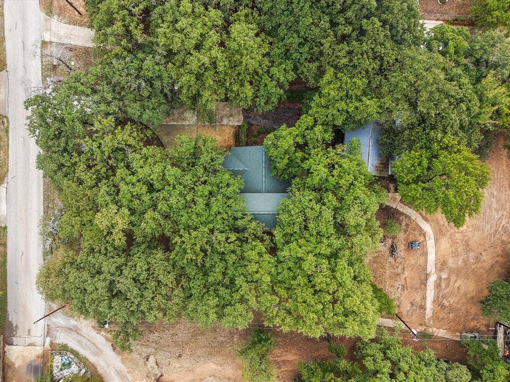 6472 Mark Drive, Burleson, TX 76028 Property surrounded by mature trees, featuring a green shingle roof