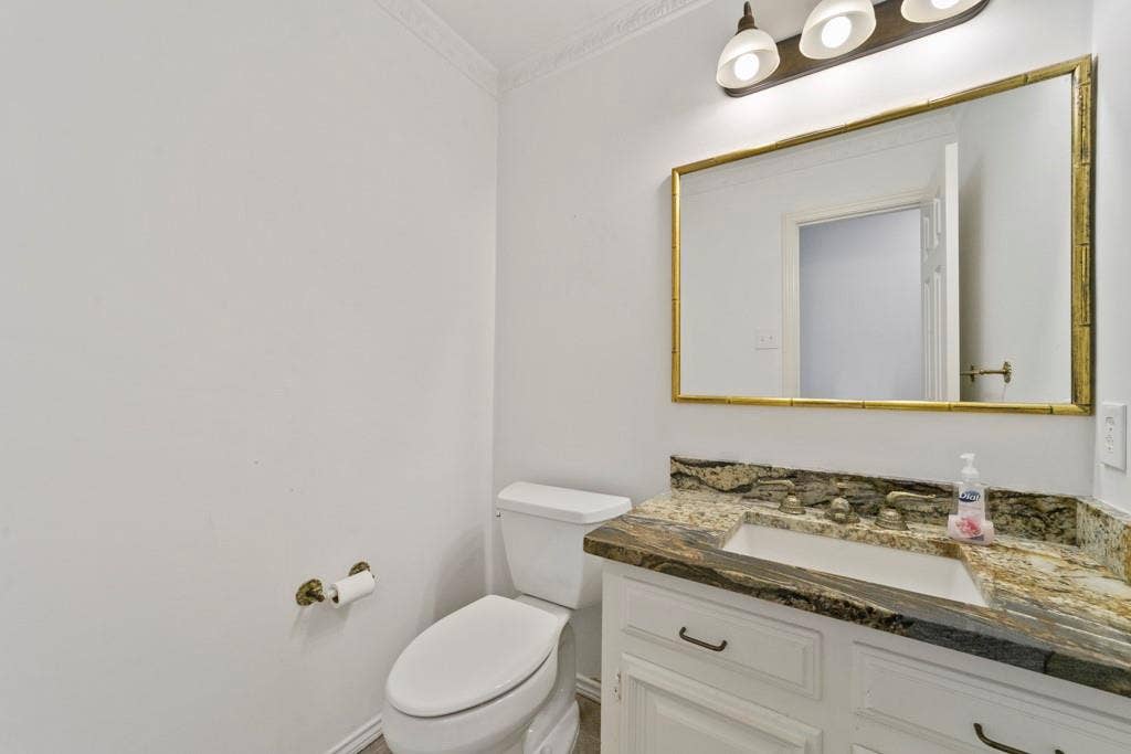 16353 Lauder Lane, Dallas, TX 75248 White vanity with dual doors and drawers, featuring a built-in sink and a patterned countertop