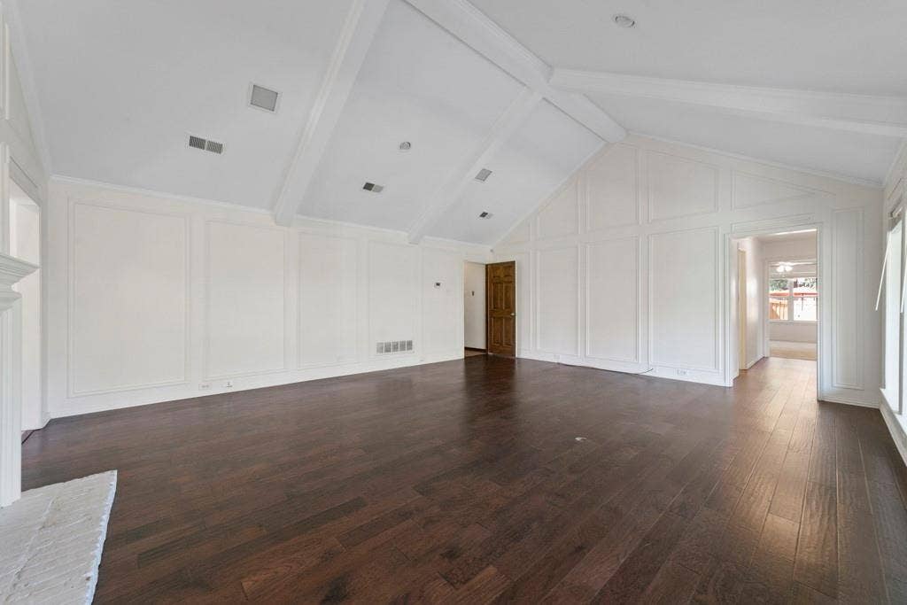 16353 Lauder Lane, Dallas, TX 75248 Vaulted ceiling with exposed beams, recessed lighting, dark wood-finish flooring, white paneled accent walls, and a white brick fireplace surround