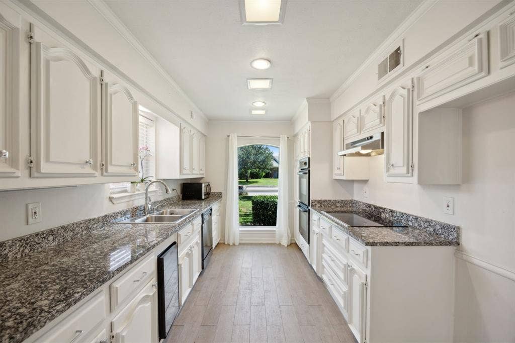16353 Lauder Lane, Dallas, TX 75248 Kitchen with white cabinetry, granite countertops, wood-finish flooring, recessed lighting, and a built-in oven