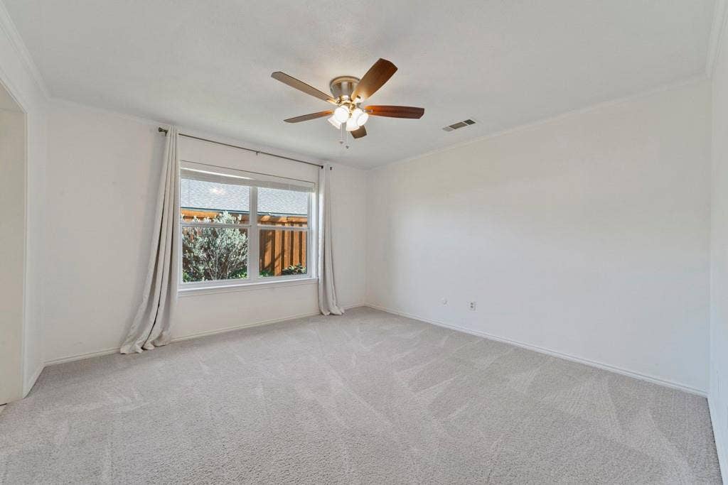 16353 Lauder Lane, Dallas, TX 75248 Spacious room featuring neutral carpeting, a multi-pane window, and a ceiling fan with integrated lighting